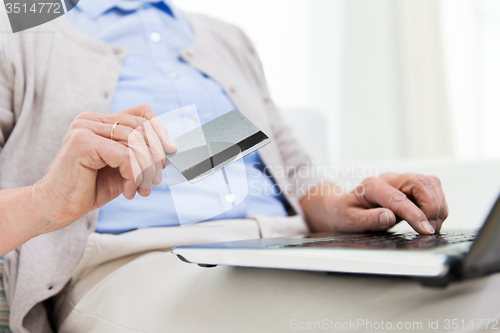 Image of senior woman with laptop and credit card at home