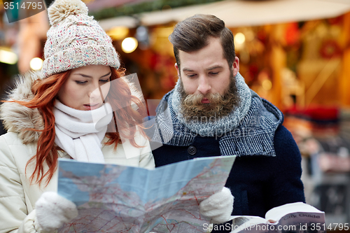 Image of happy couple with map and city guide in old town