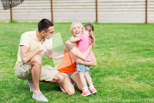 Image of happy family hugging outdoors