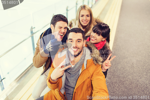 Image of happy friends taking selfie on skating rink