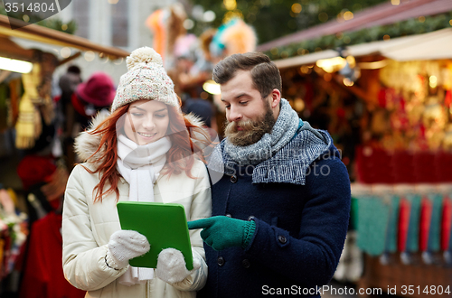 Image of happy couple walking with tablet pc in old town