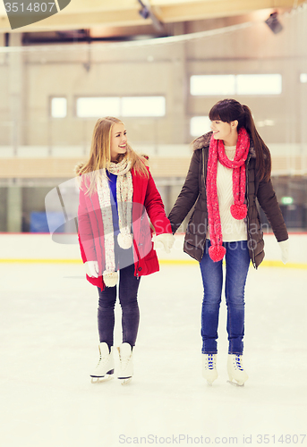 Image of happy girls friends on skating rink