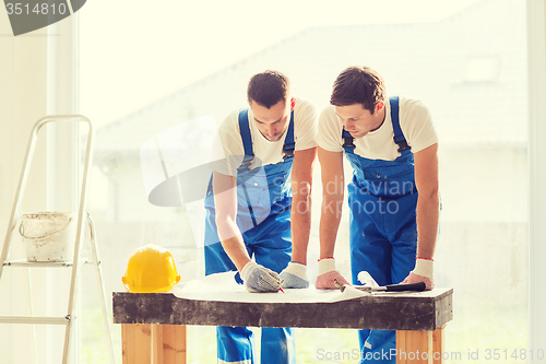 Image of group of builders with blueprint