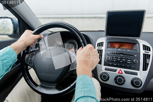 Image of close up of young man with tablet pc driving car