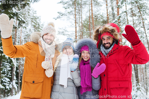 Image of group of friends waving hands in winter forest