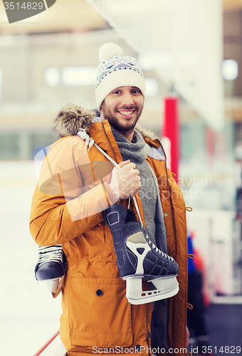 Image of happy young man with ice-skates on skating rink