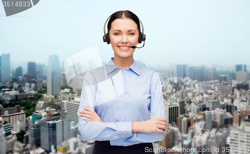 Image of helpline operator in headset over city background