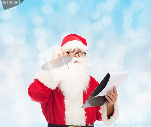 Image of man in costume of santa claus with notepad