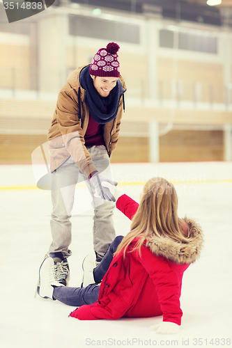 Image of man helping women to rise up on skating rink