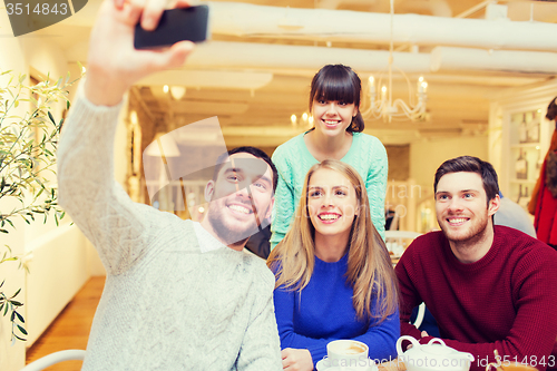 Image of group of friends taking selfie with smartphone