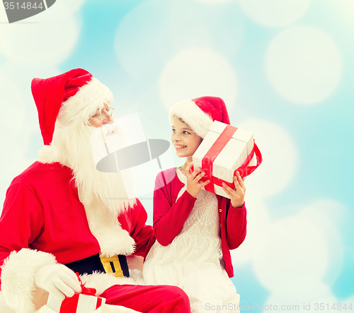 Image of smiling little girl with santa claus and gifts