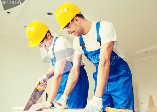 Image of group of builders with tools indoors