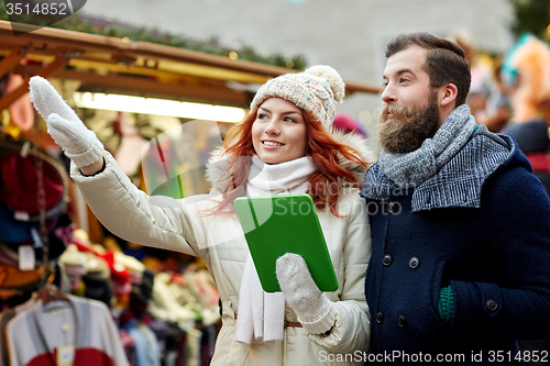 Image of happy couple walking with tablet pc in old town