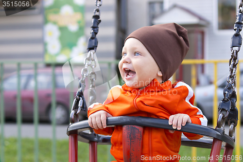 Image of Joyful toddler on a swing