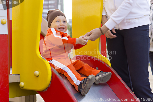 Image of Kid with a smile on children's slide