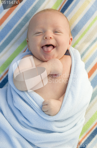 Image of Laughing Baby Boy Wrapped in His Blanket