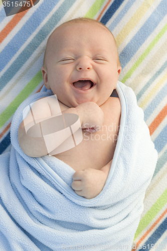 Image of Laughing Baby Boy Wrapped in His Blanket