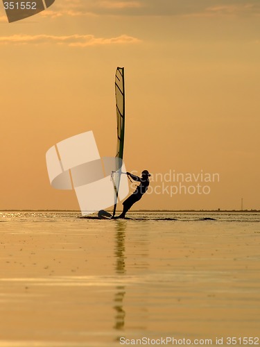 Image of Silhouette of a wind-surfer on waves of a gulf on a sunset 1