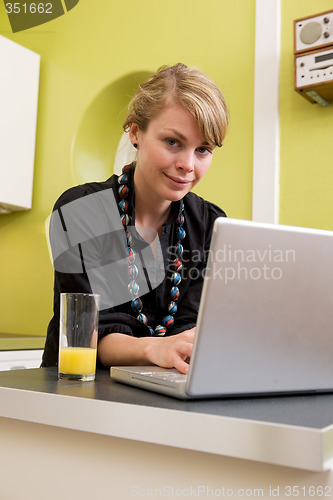 Image of Woman Using Computer in Kitchen