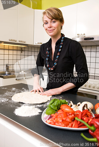 Image of Young Woman Making Pizza Dough