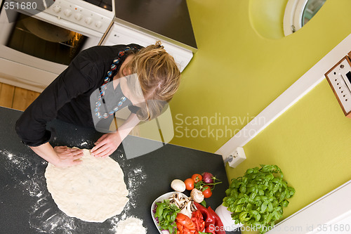 Image of Young Woman Making Pizza Dough