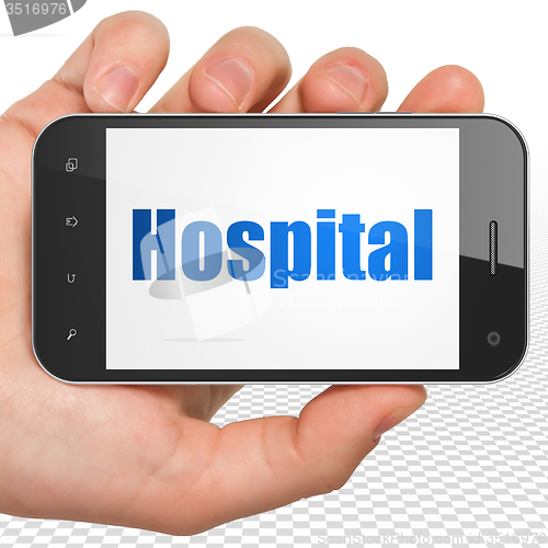 Image of Health concept: Hand Holding Smartphone with Hospital on display