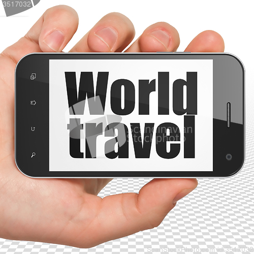 Image of Tourism concept: Hand Holding Smartphone with World Travel on display