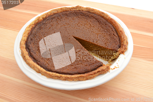 Image of Slice cut from a pumpkin pie in a dish
