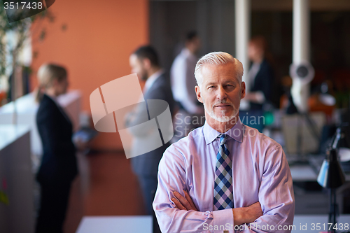 Image of senior business man with his team at office