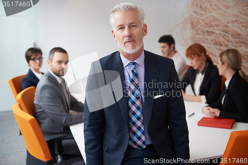 Image of senior business man with his team at office