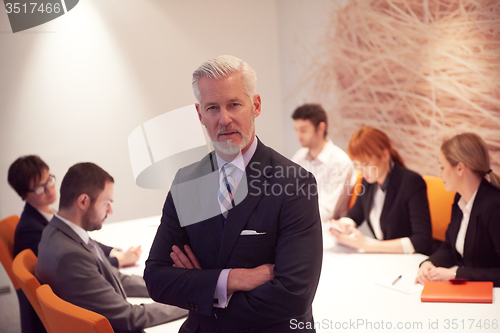 Image of senior business man with his team at office