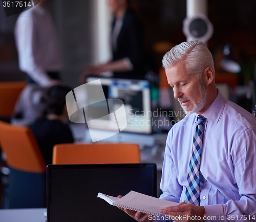 Image of senior business man with his team at office