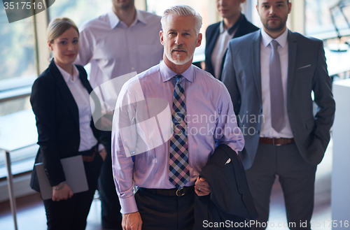 Image of senior business man with his team at office
