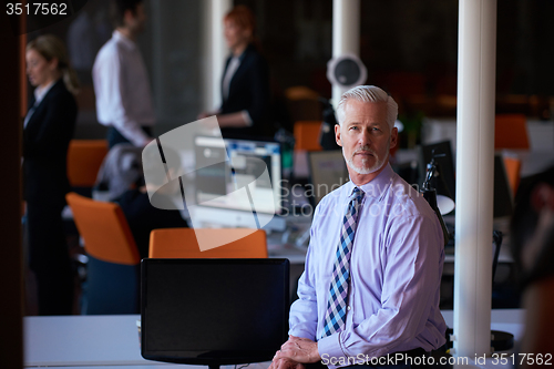 Image of senior business man with his team at office