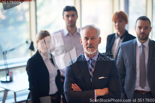 Image of senior business man with his team at office