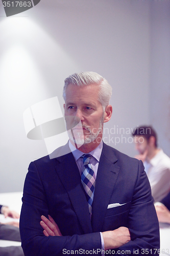 Image of senior business man with his team at office