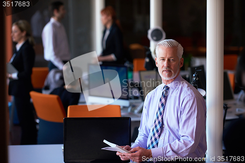 Image of senior business man with his team at office