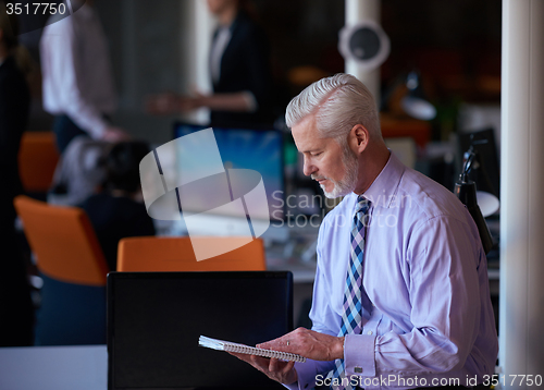 Image of senior business man with his team at office
