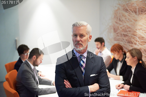 Image of senior business man with his team at office