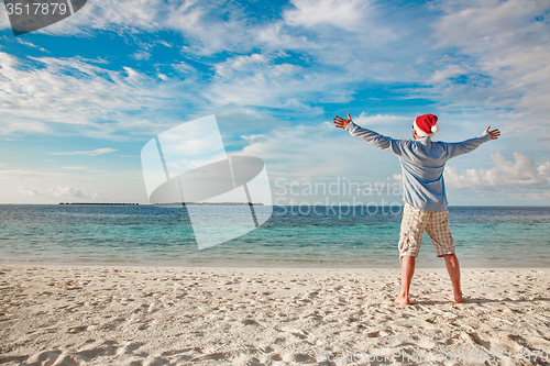 Image of Man in santa hat on the tropical beach