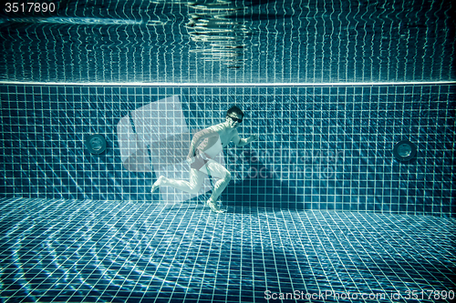 Image of Man runs underwater swimming pool