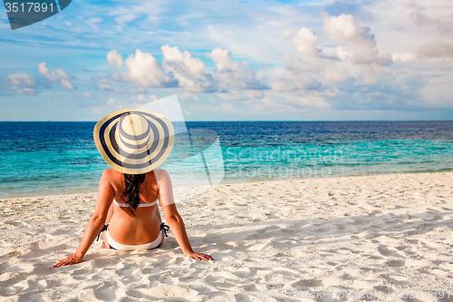 Image of Girl walking along a tropical beach in the Maldives.