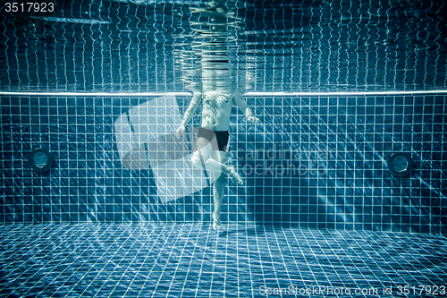 Image of Persons standing under water in a swimming pool