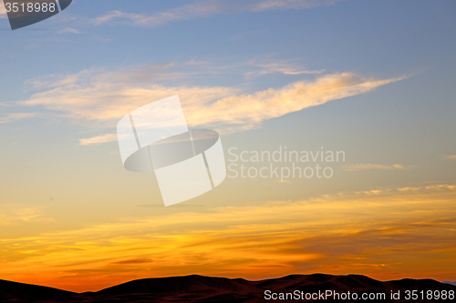 Image of the sunrise in  colored sky white  mountain background