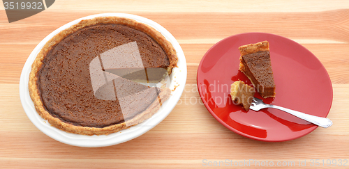 Image of Pumpkin pie for Thanksgiving with a slice on a plate