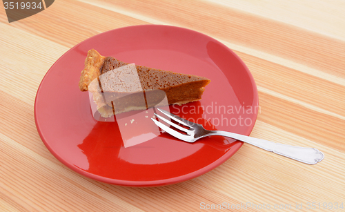 Image of Slice of pumpkin pie with a fork on a plate