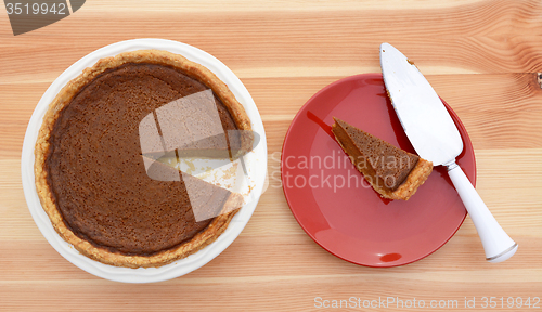 Image of Slice taken from a pumpkin pie with pie server