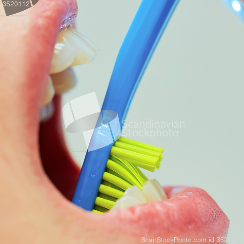 Image of Dentist showing a woman how to brush her teeth