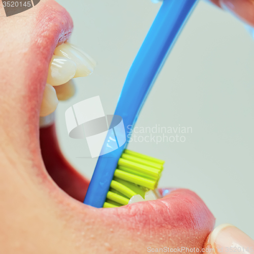 Image of Dentist showing a woman how to brush her teeth