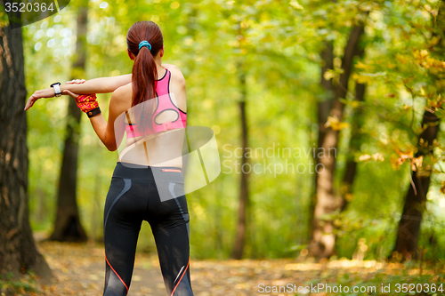 Image of woman runner stretching before her workout